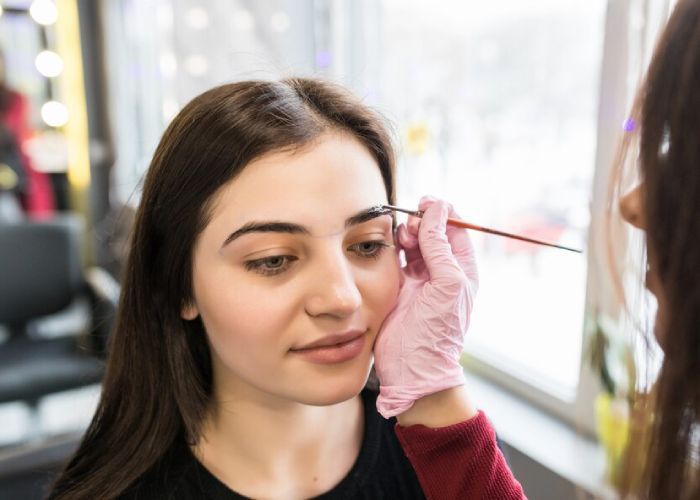 smiling-model-is-doing-eyebrow-painting-procedure_