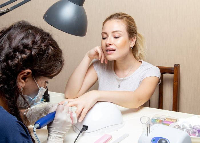 front-view-young-female-getting-her-nails-fixed-by